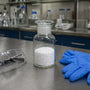 Phenibut powder in sealed lab container with safety equipment