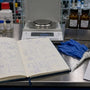 Research lab notebook beside labeled compound vials