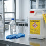 Labeled chemical waste container on a laboratory bench for research waste disposal