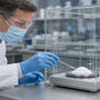 Researcher weighing phenibut HCl in a ventilated enclosure