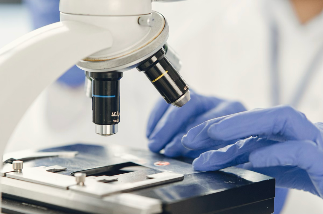 a scientist researching a compound material under a microscope