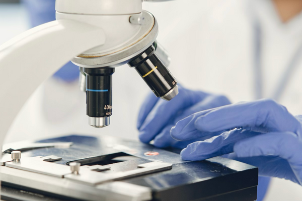 a scientist researching a compound material under a microscope
