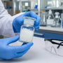 Nitrile gloves handling pramiracetam powder container in research lab 