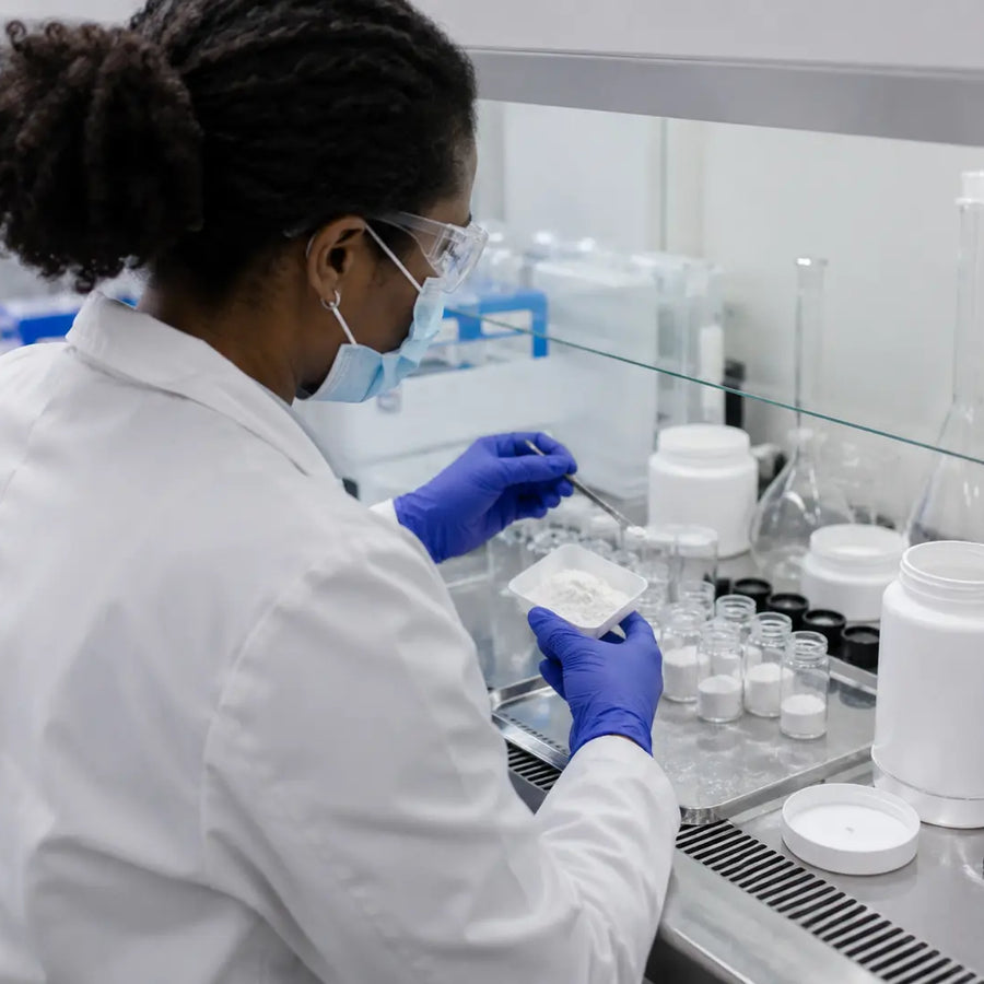 Lab technician filling vials with Pramiracetam powder