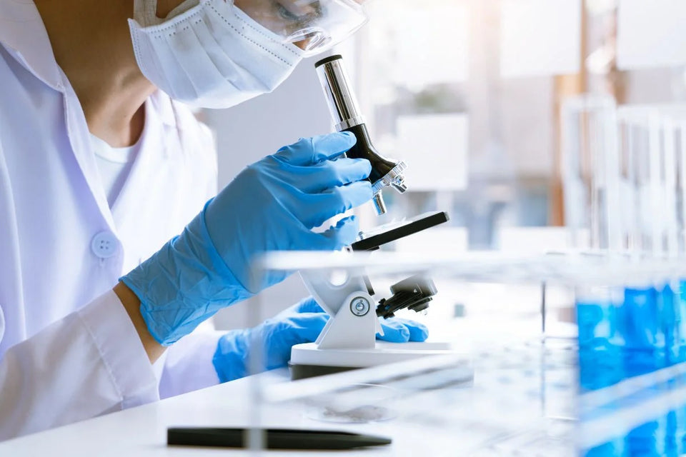 Woman using microscope on research chemicals